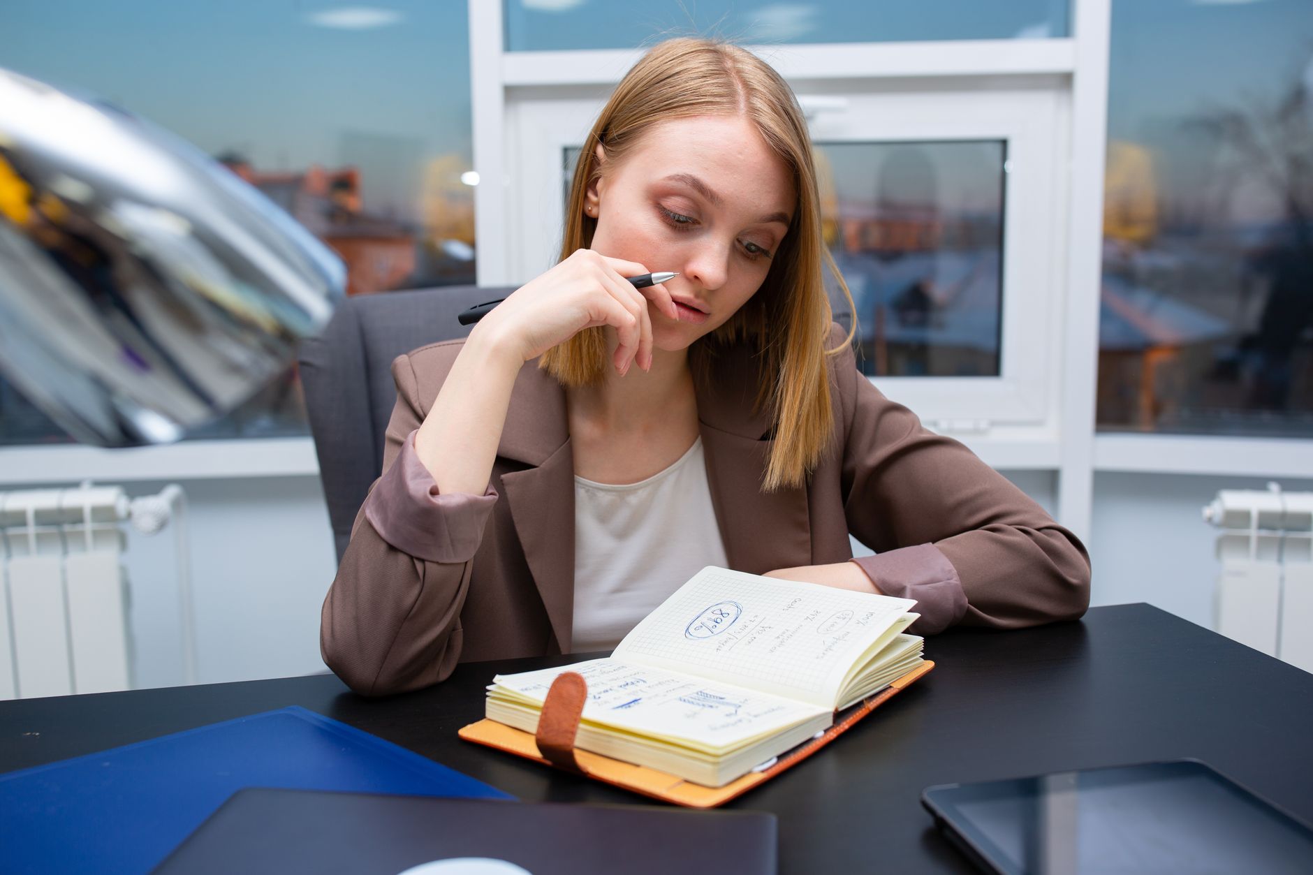 A real estate agent sketching a one-page business plan at a desk