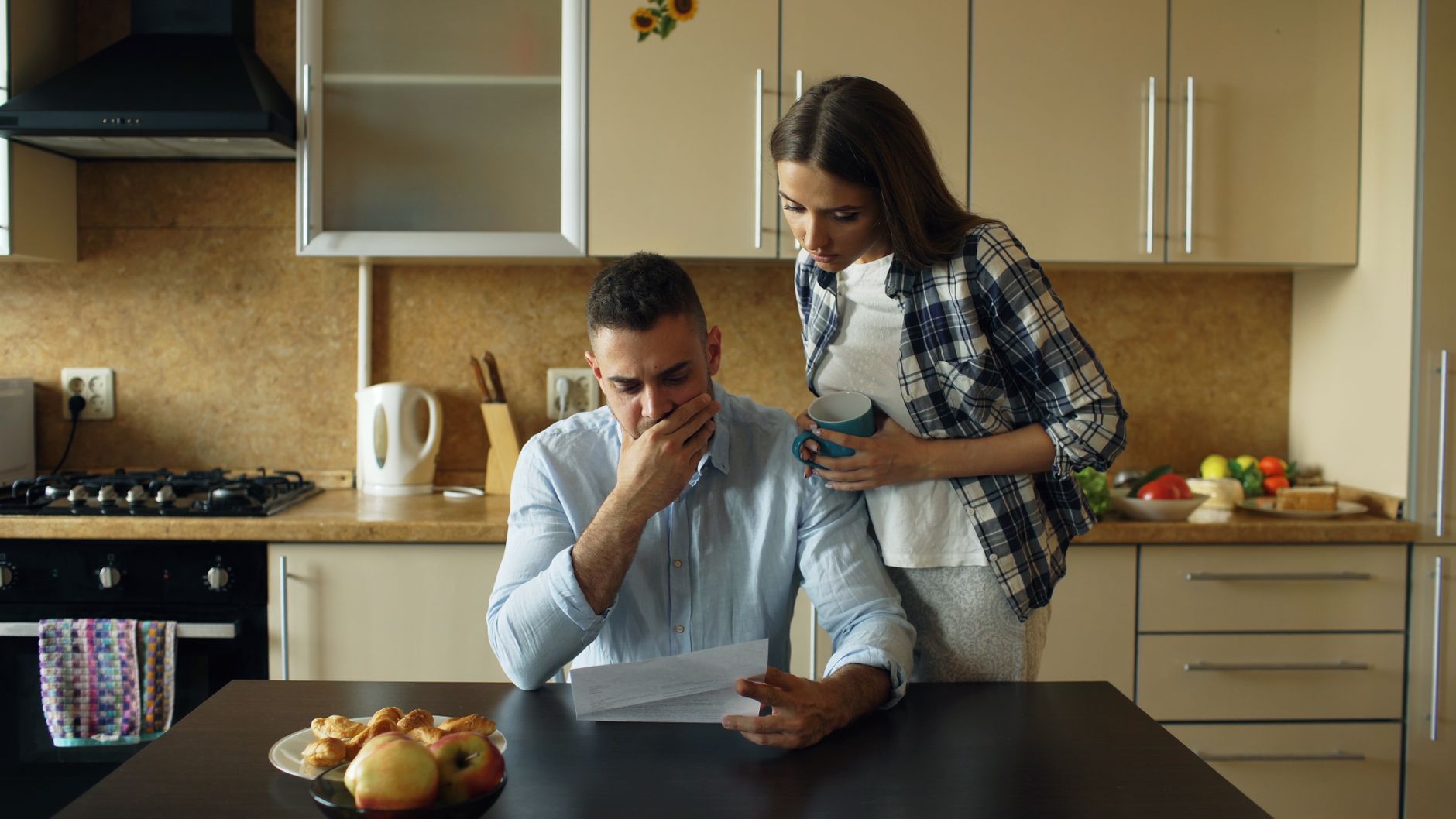 A homeowner reading a seasonal maintenance checklist at the kitchen table