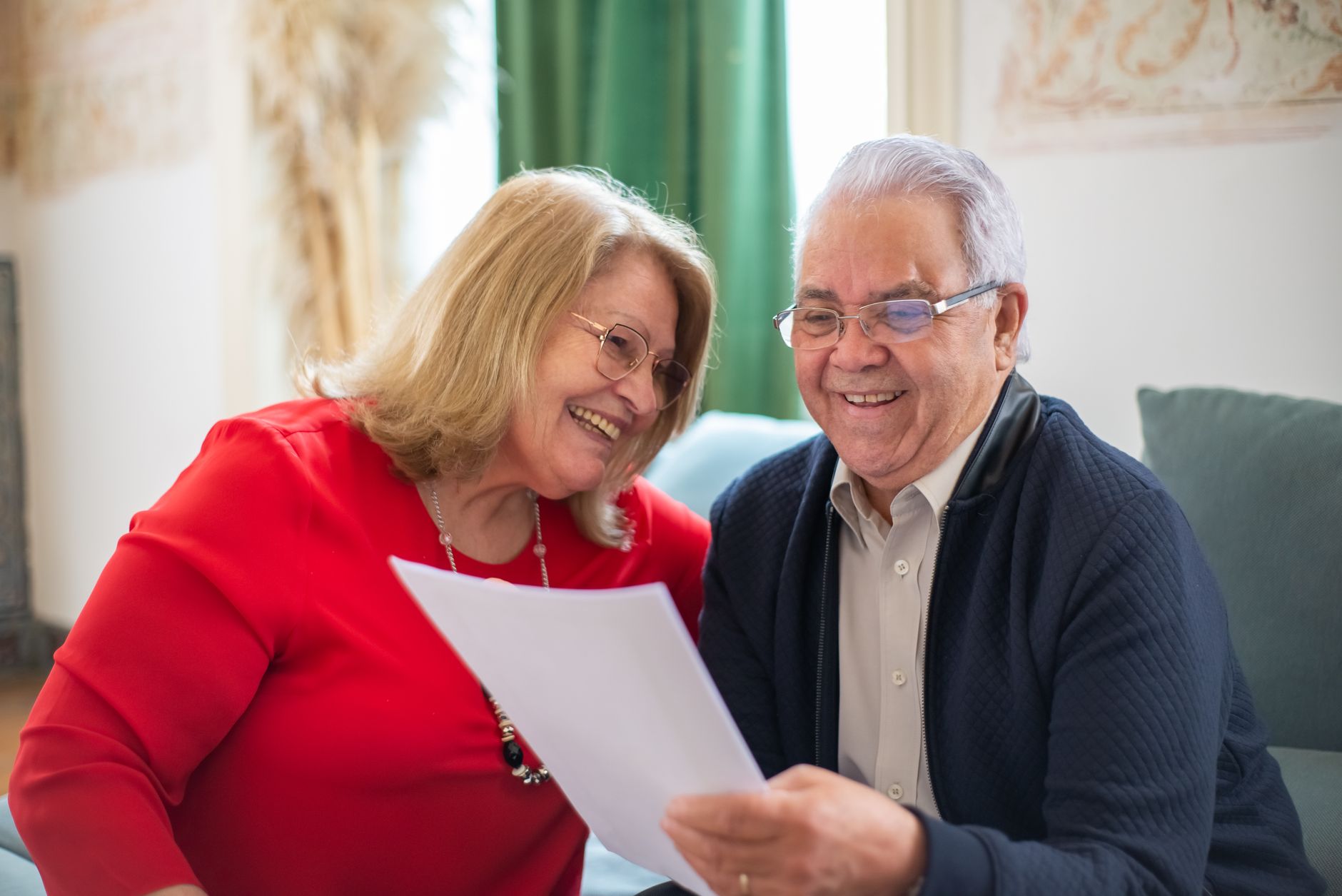 A past client smiling while reading a card from their agent